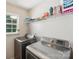 Bright laundry room with shelving, front-loading washer, and window at 9200 Forest Green Dr, Charlotte, NC 28227