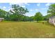 Expansive backyard with lush green grass and mature trees, perfect for outdoor activities at 1009 Rainbow Cir, Catawba, SC 29704