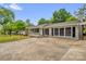 Single-story home with neutral paint, dark shutters, a covered porch, and a spacious driveway at 105 N Baldwin Ave, Kannapolis, NC 28083