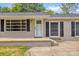 Close-up of charming, neutral painted home, dark shutters, covered porch, and well-kept landscaping at 105 N Baldwin Ave, Kannapolis, NC 28083