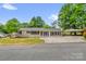 Charming single-story home with neutral paint, dark shutters, well-maintained lawn and convenient covered parking at 105 N Baldwin Ave, Kannapolis, NC 28083