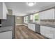 Bright kitchen featuring granite countertops, stainless steel appliances, white cabinets, and hardwood floors at 105 N Baldwin Ave, Kannapolis, NC 28083