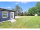 Backyard view features blue vinyl siding, a concrete patio, and a partial view of mature shade trees at 11 Cobblestone Nw Ln, Concord, NC 28027