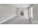 Large and well-lit bonus room with soft carpet, and backyard view through windows and glass doors at 11 Cobblestone Nw Ln, Concord, NC 28027
