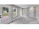 Bright bonus room with large backyard view through windows and glass doors, and plush gray carpeting at 11 Cobblestone Nw Ln, Concord, NC 28027
