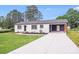 Charming single-story home with white brick, dark roof, front lawn, and covered parking area at 11 Cobblestone Nw Ln, Concord, NC 28027