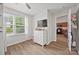 Bedroom features wood-look floors, a white dresser with TV, and a view of the kitchen at 117 S Canyon Ridge S Dr, Mount Holly, NC 28120