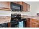 Close-up of kitchen features black appliances and ample cabinet space at 117 S Canyon Ridge S Dr, Mount Holly, NC 28120