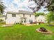 A full backyard shot of home, with lawn, trees, patio, and an outdoor fire pit at 11719 Withers Mill Dr, Charlotte, NC 28278