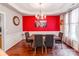 Dining room boasts hardwood floors, tray ceiling, a red accent wall, and elegant chandelier at 11719 Withers Mill Dr, Charlotte, NC 28278