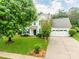Charming two-story home with white siding, green shutters, well-manicured lawn, and a two-car garage at 11719 Withers Mill Dr, Charlotte, NC 28278
