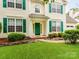 Attractive home featuring green shutters, an inviting entrance, and lovely landscaping. For Sale by Canopy2025 at 11719 Withers Mill Dr, Charlotte, NC 28278