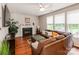 Comfortable living room featuring a cozy fireplace, hardwood floors, and a large brown sectional sofa at 11719 Withers Mill Dr, Charlotte, NC 28278