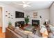 Cozy living room with a fireplace, hardwood floors, and a plush brown sectional sofa at 11719 Withers Mill Dr, Charlotte, NC 28278