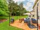 Inviting backyard patio featuring ample seating, an umbrella, a grill, and manicured lawn at 11719 Withers Mill Dr, Charlotte, NC 28278