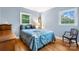 Bright bedroom featuring wood floors, two windows and a comfortable bed with stylish bedding at 1287 Queensgate St, Gastonia, NC 28054