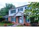 Charming two-story home with red brick facade, white siding, and vibrant landscaping at 1287 Queensgate St, Gastonia, NC 28054