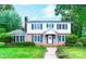 Charming two-story home featuring a brick facade, white siding, green shutters, and a neatly landscaped front yard at 1287 Queensgate St, Gastonia, NC 28054