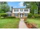 Traditional two-story home with brick and white siding, green shutters, and a beautifully landscaped front yard at 1287 Queensgate St, Gastonia, NC 28054