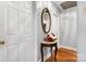 Hallway featuring hardwood floors, white doors, and a decorative table with a bouquet of flowers at 1287 Queensgate St, Gastonia, NC 28054