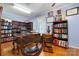 Well-appointed home office with hardwood floors, built-in bookshelves, and a large wooden desk at 1287 Queensgate St, Gastonia, NC 28054