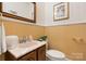 Classic powder room featuring a marble countertop vanity, decorative mirror, and neutral finishes at 1287 Queensgate St, Gastonia, NC 28054