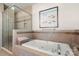 Relaxing bathroom featuring a luxurious soaking tub and glass-enclosed shower at 13216 Old Compton Ct, Pineville, NC 28134