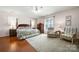 Spacious bedroom with a four-poster bed, hardwood floors, and natural light at 13216 Old Compton Ct, Pineville, NC 28134