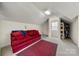 Finished bonus room featuring neutral carpeting, a cozy red sofa, and additional space for storage at 13216 Old Compton Ct, Pineville, NC 28134