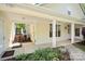A sun-drenched exterior featuring an inviting back porch with lush plants and a brick paver walkway at 13216 Old Compton Ct, Pineville, NC 28134