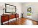 Foyer with hardwood floors, a decorative mirror, a wooden console table, and a glass-paned front door at 13216 Old Compton Ct, Pineville, NC 28134