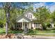 Charming two-story home with a well-manicured lawn, walkway, mature trees, and cozy front porch at 13216 Old Compton Ct, Pineville, NC 28134