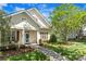 Inviting home featuring a charming facade, landscaped yard, and cozy front porch seating area at 13216 Old Compton Ct, Pineville, NC 28134