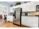 Well-lit kitchen featuring stainless steel refrigerator, and white cabinetry with hardware at 13216 Old Compton Ct, Pineville, NC 28134