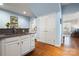 Kitchen area with white cabinets, stainless steel sink, and hardwood flooring at 13216 Old Compton Ct, Pineville, NC 28134