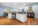 The kitchen features a central island with white cabinets, stainless steel dishwasher, and hardwood floors at 13216 Old Compton Ct, Pineville, NC 28134