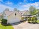 Aerial view of a home featuring an attached garage, mature trees, and a well-manicured lawn at 13216 Old Compton Ct, Pineville, NC 28134