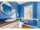 Cozy bathroom with blue walls, wood floors and updated fixtures at 1340 Piccadilly Dr, Charlotte, NC 28211