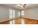 Sunlit bedroom with hardwood floors, ceiling fan, and double doors leading to outside at 1340 Piccadilly Dr, Charlotte, NC 28211