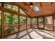 Relaxing screened-in patio with wood ceiling, fan and views of the wooded back yard at 1340 Piccadilly Dr, Charlotte, NC 28211