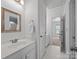 Bright bathroom featuring a vanity, mirror, and a doorway with a view of a carpeted bedroom at 18305 Dembridge Dr, Davidson, NC 28036