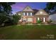 Stately two-story brick home with manicured lawn, blue shutters, and a welcoming entrance at 18305 Dembridge Dr, Davidson, NC 28036