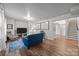 Living room with hardwood floors, a blue couch, a television, and a staircase at 18305 Dembridge Dr, Davidson, NC 28036