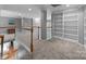 A spacious upper loft featuring a wall of built-in bookshelves and soft, neutral carpeting at 18305 Dembridge Dr, Davidson, NC 28036