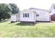 View of home's back exterior, featuring vinyl siding, green grass, and a small window at 201 Mitchell St, Belmont, NC 28012