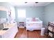 Charming bedroom featuring a crib, hardwood floors, and soft lighting at 201 Mitchell St, Belmont, NC 28012