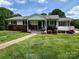 Charming single story home with a brick foundation, cozy porch swing, and a well-manicured lawn at 201 Mitchell St, Belmont, NC 28012