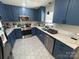 Updated kitchen featuring blue cabinets, stainless steel appliances, and white countertops at 201 Mitchell St, Belmont, NC 28012