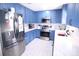 Well-lit kitchen with stainless steel appliances, blue cabinets, and white countertops for a sleek, modern look at 201 Mitchell St, Belmont, NC 28012