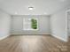 Empty room with light wood flooring, neutral walls, and a large window, providing a blank canvas at 2020 Embassy Ct # 48, Charlotte, NC 28213